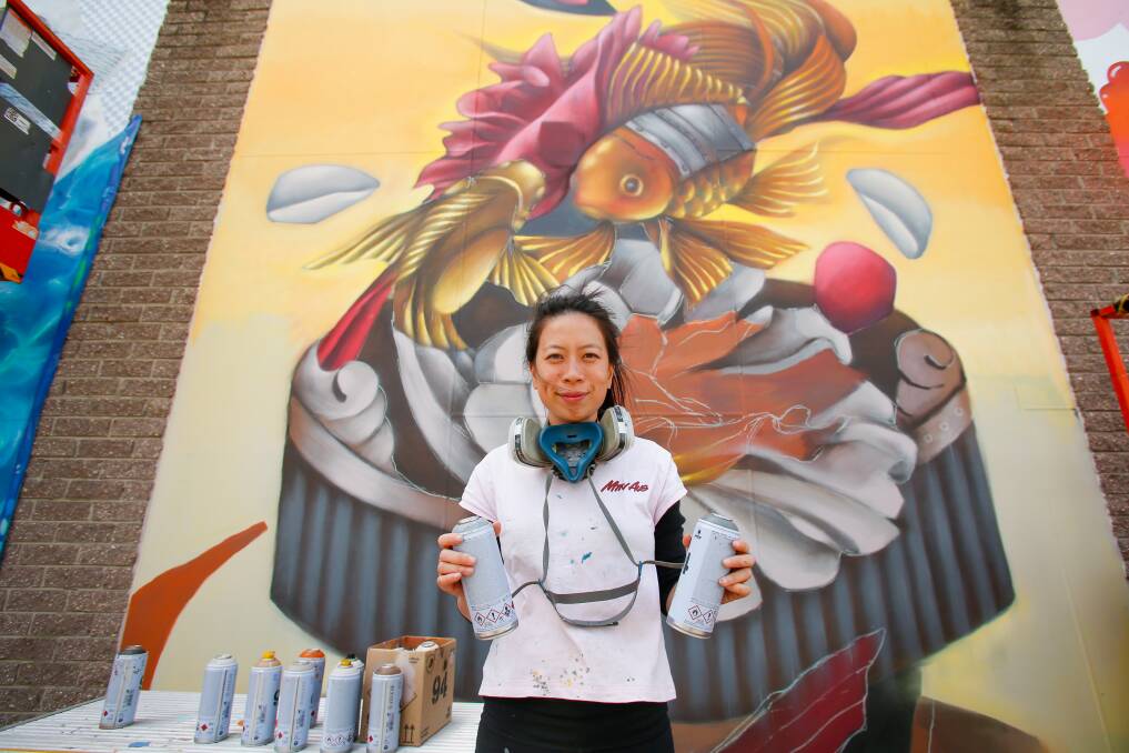 Street artist Christina Huinh a.k.a. Styna at work in Port Kembla for the Wonderwalls festival. Picture by Anna Warr.
