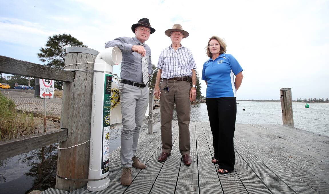 Waste kills birds: Gordon Bradbery with Arthur Booth and Kirsten Hort near one of the bins at the Windang boat ramp. Picture: Sylvia Liber