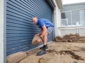 Thirroul Surf Club captain Ian Sakoff said 'the sandbags saved us' after sea water, sand and debris innundated Thirroul Esplanade but did not penetrate the club. Picture: Anna Warr
