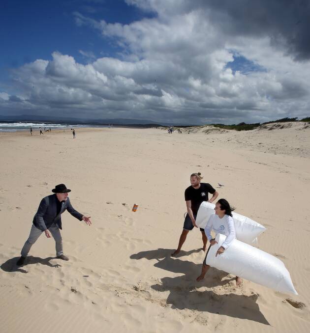 Pick it up: Lord Mayor Gordon Bradbery, Blake Doering from Port Kembla Boardriders and Susie Crick from Surfrider Foundation try to bag a can at Port Kembla Beach. Picture: Robert Peet