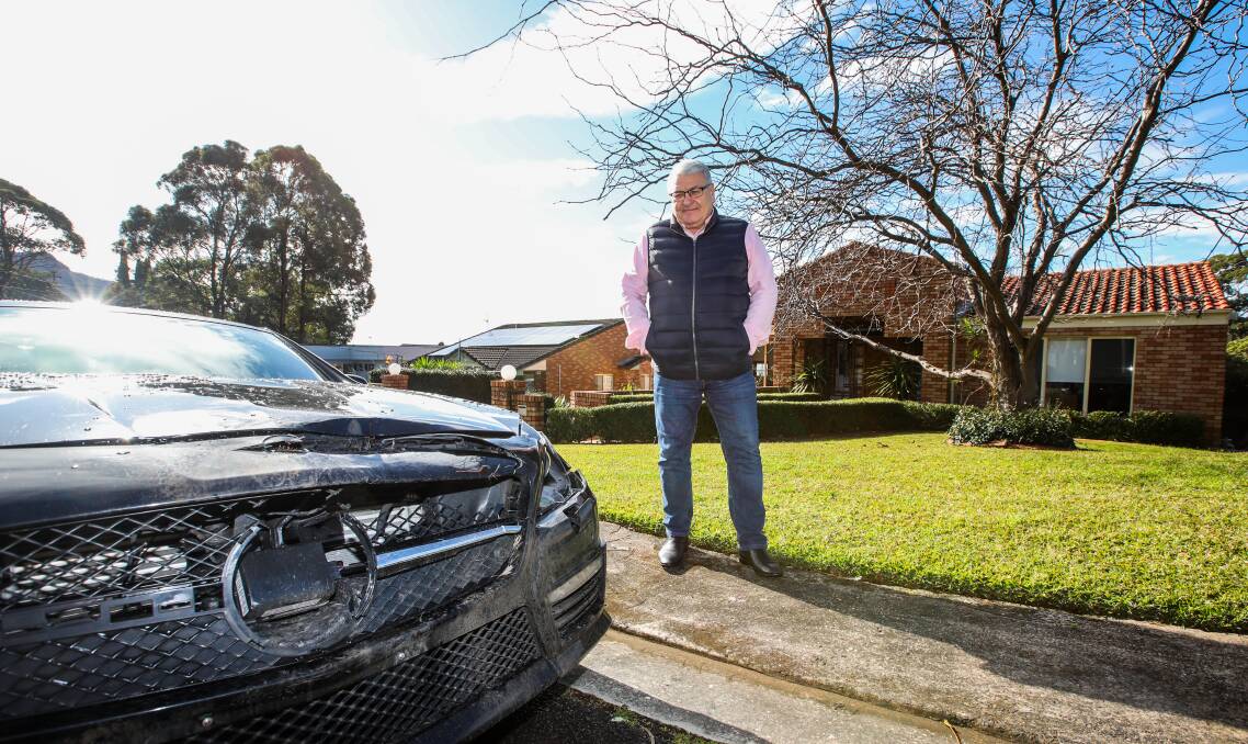 LUCKY: Wollongong man John Apolloni with his car which was seriously damaged by a deer strike on the M1. He said a less trained or focused driver could have been worse off. Picture: Wesley Lonergan