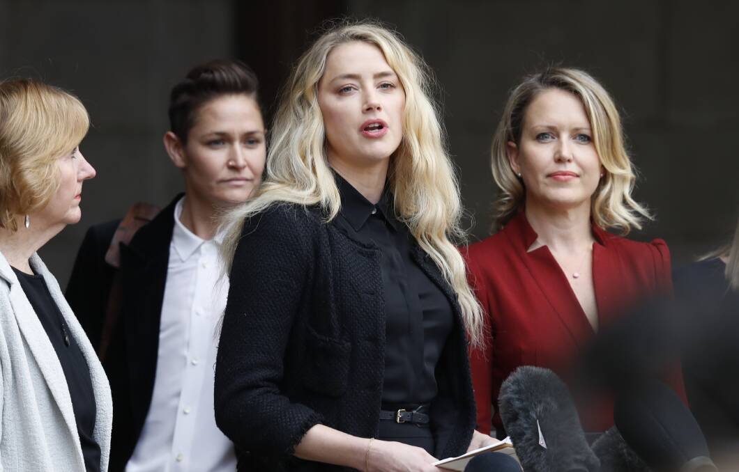 Robinson (right) with actor Amber Heard outside the High Court in London in July. Picture: AP.