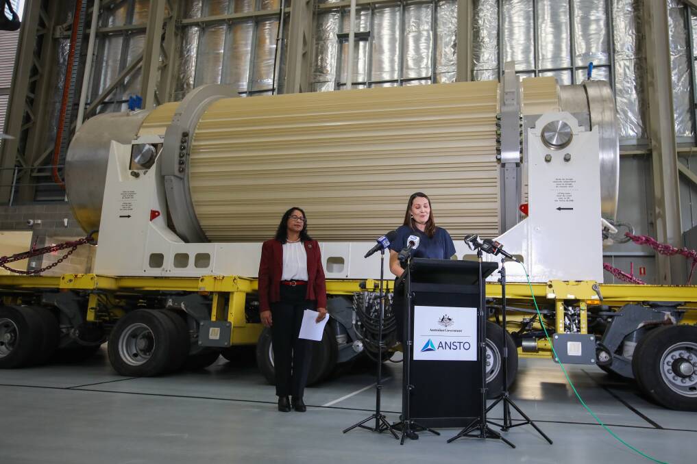 ANSTO's Paula Berghofer (front) and Pamela Naidoo-Ameglio address the media after the repatriation of a radioactive waste canister (back) to Lucas Heights last weekend. Picture: WESLEY LONERGAN.