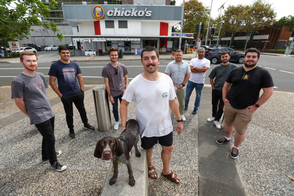 Here they come - Zac Philippa (centre) with dog Belle and workmates from Stantec outside Chicko's in Wollongong. Picture by Adam McLean.