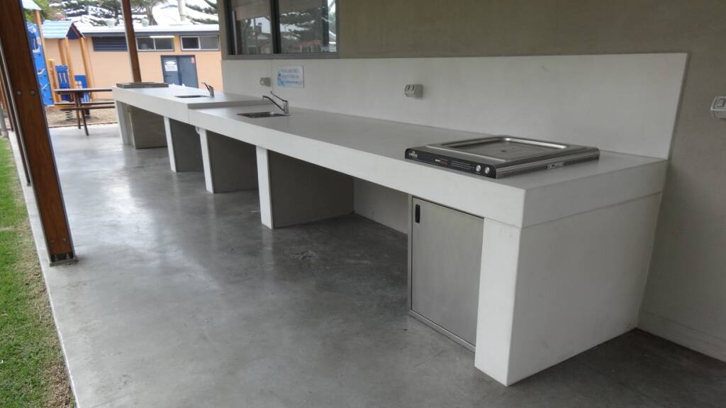 An outdoor double barbecue and bench setup made for a caravan park owned by Shellharbour City Council