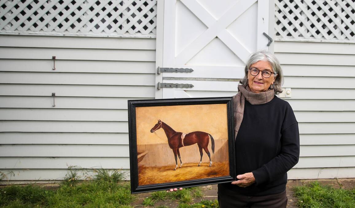 RESTORED TO ITS FORMER GLORY: Marg Lucas with the painting of Postboy she found at the Fletcher Jones Market. 
