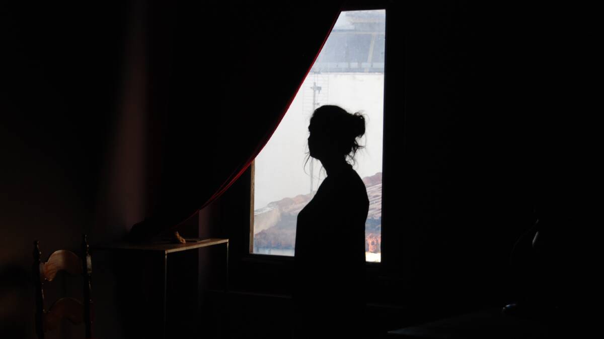 A stock image of a woman in silhouette looking out a window. Picture from Shutterstock