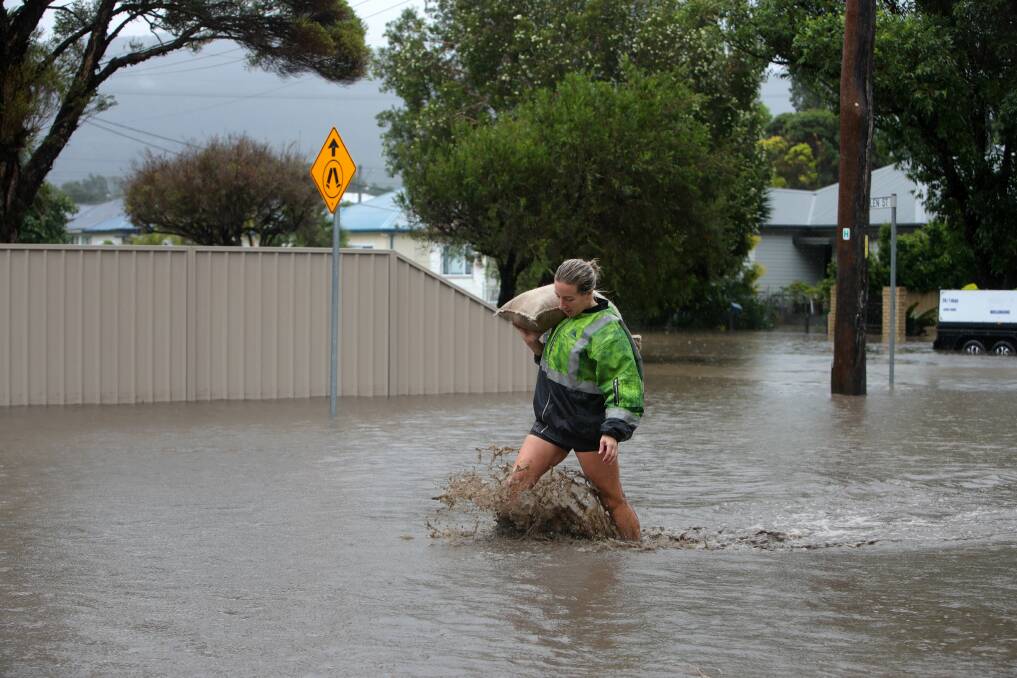 Stephanie Truscott carts sandbags to help protect her neighbours' homes in Bellambi. Picture: Sylvia Liber