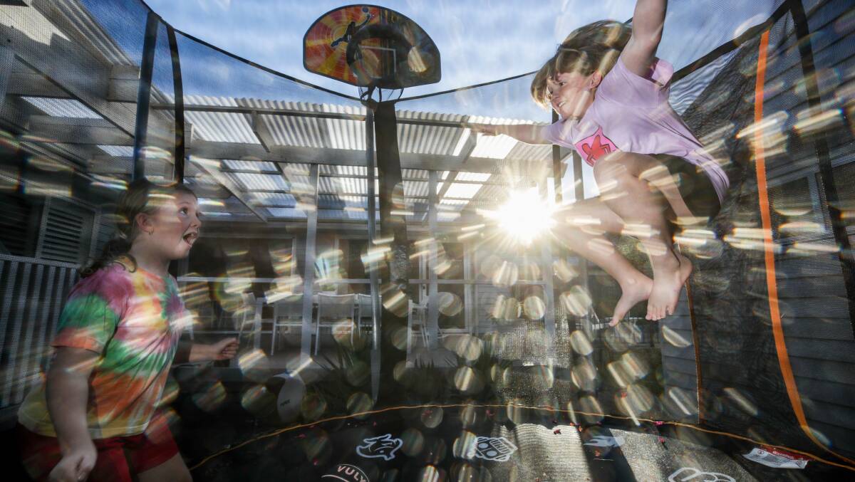 Charli Gerrey and sister Chloe enjoy a sunny afternoon on the trampoline. Picture: Adam McLean