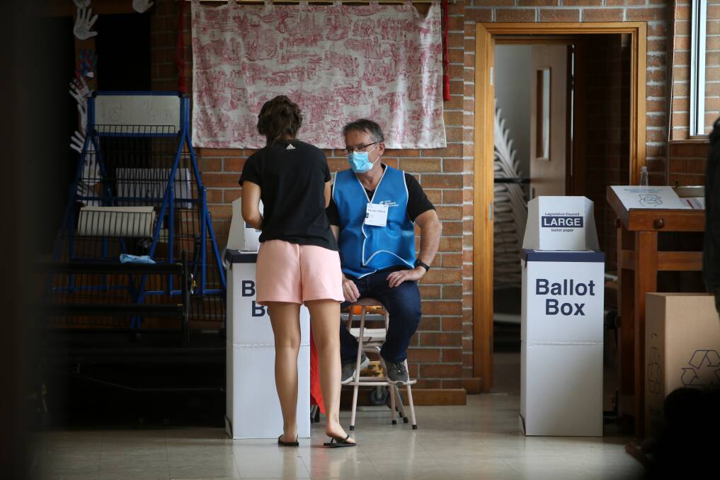 A voter submits their ballot papers at St Pius X Catholic Primary School in Unanderra. Picture: Sylvia Liber