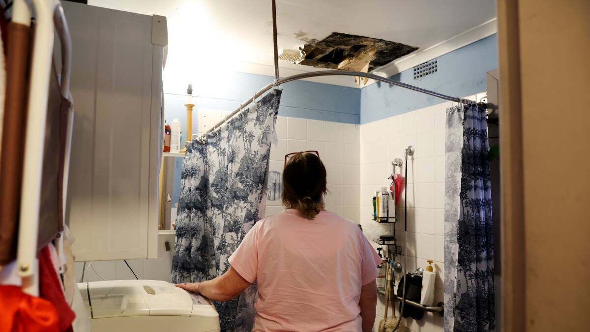 Jennifer in her bathroom, which has been consistently flooded by a leak from upstairs for years. 