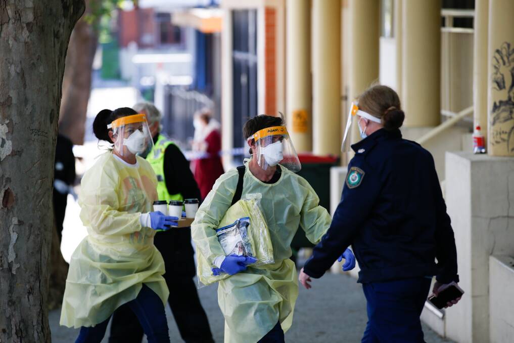 Workers and police don personal protective equipment at the Keira Street site. Picture: Anna Warr