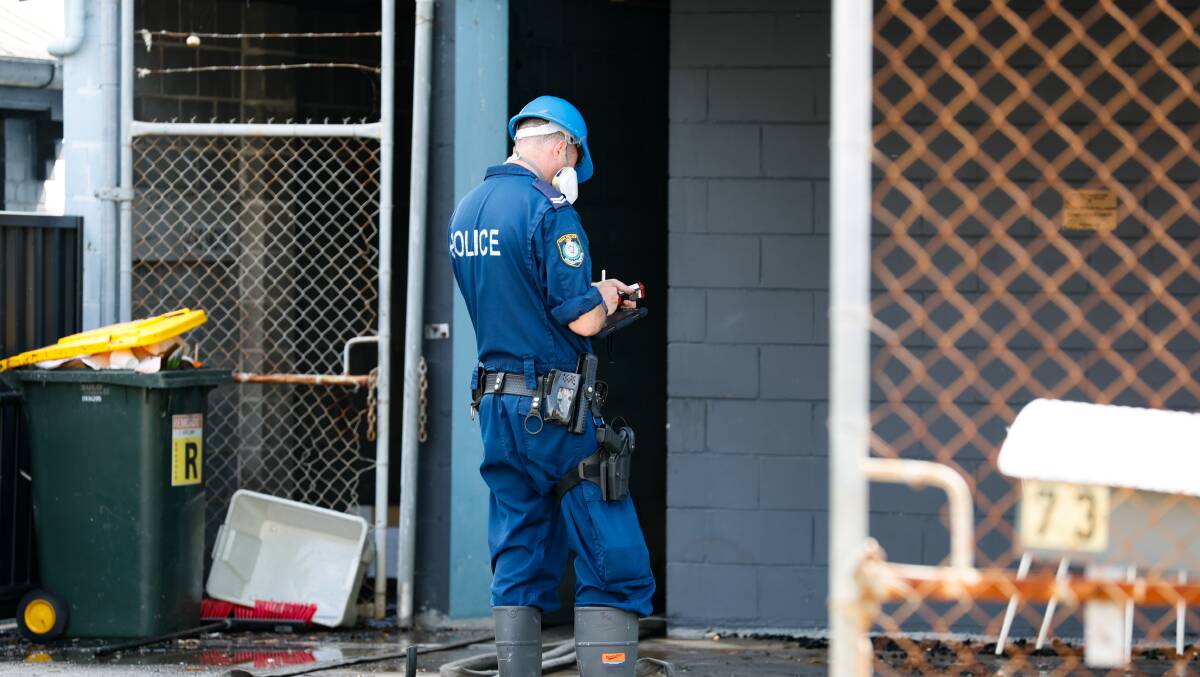 A police officer at the scene of the suspicious fire in Port Kembla on Wednesday. Picture by Anna Warr
