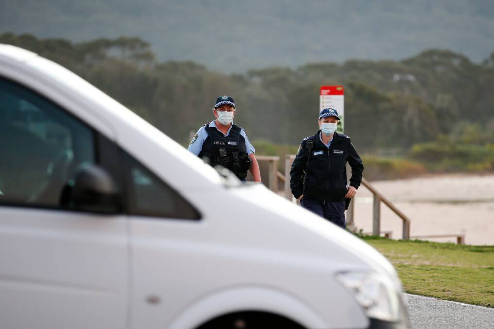 RULES: Police officers conduct compliance checks at the car park near Bellambi Beach. Picture: Anna Warr
