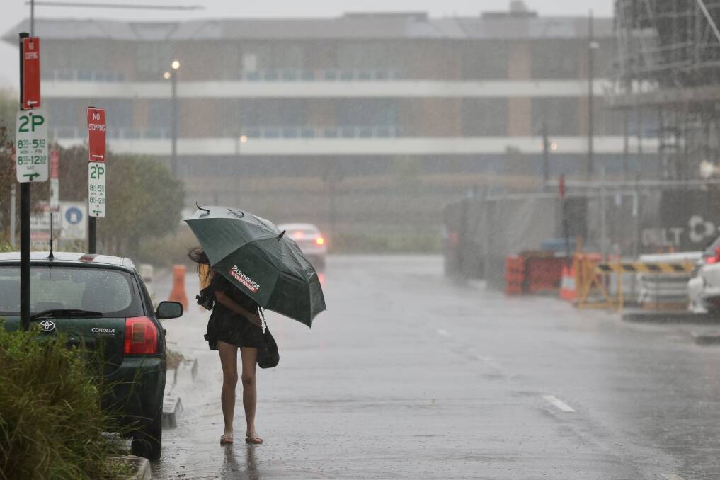 A person shelters under an umbrella on a rainy day in Shell Cove. File picture by Adam McLean