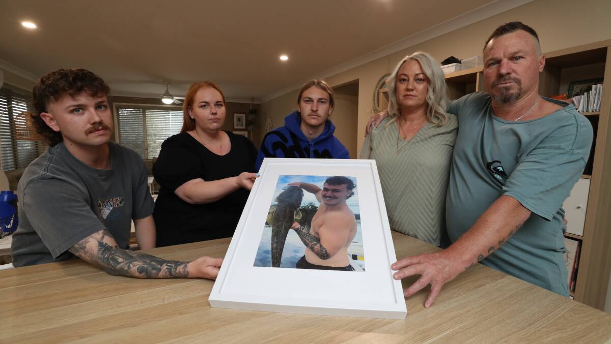 Brayden Chater's family - cousin Callum Young, older sister Shayne, younger brother Harry, mum Stacey and dad Ralph - with a photograph of the keen fisherman taken in Lake Conjola in 2022. Picture by Robert Peet