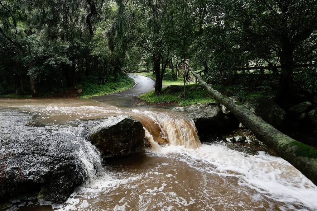 Water flows over a road at Calderwood. Picture: Adam McLean