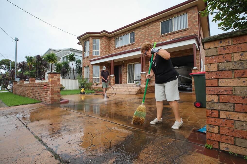 Janette and David Bessell help clean up a family member's home at the southern end of Kembla Street after this week's flooding. Picture: Wesley Lonergan
