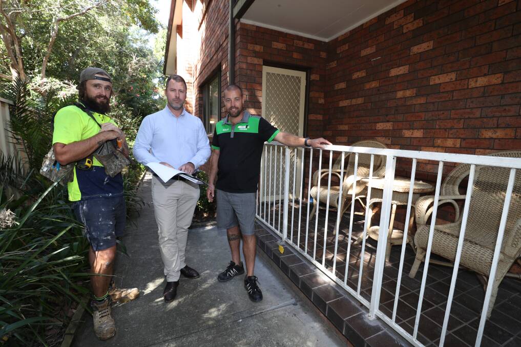 IMPROVEMENTS: Housing Trust program coordinator Luke Attenborough, centre, with Will Nielsen and Dale Perrett from On Board Building Services at one of the properties set for upgrade. Picture: Robert Peet