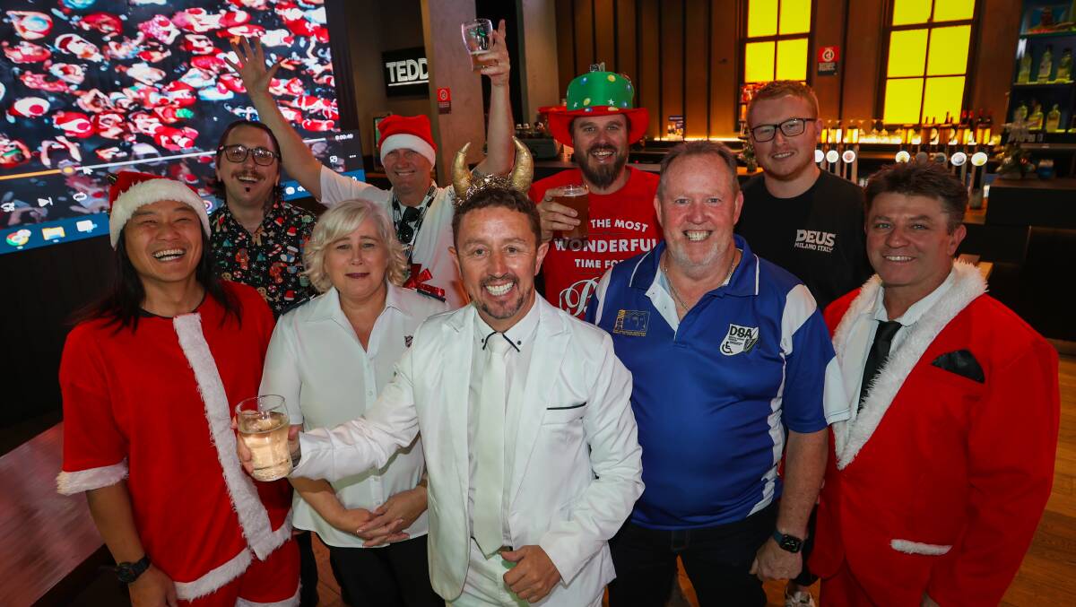 Organiser Neil Webster, centre, with the Salvation Army's Karen Walker, left, and Disabled Surfers Association of Australia's Bryan Rugg, right, and other SantaFest fans. Picture by Wesley Lonergan