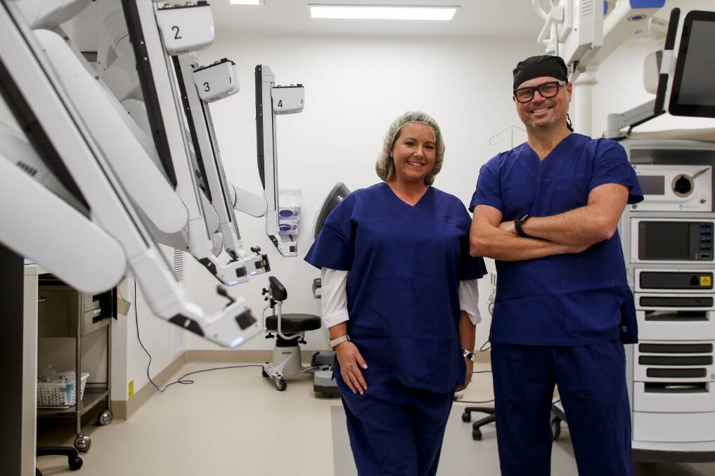 High tech: Woonona woman Emma Wallace with her surgeon Dr Stephen Pearson, and the da Vinci robotic surgical assistant. Picture: Anna Warr