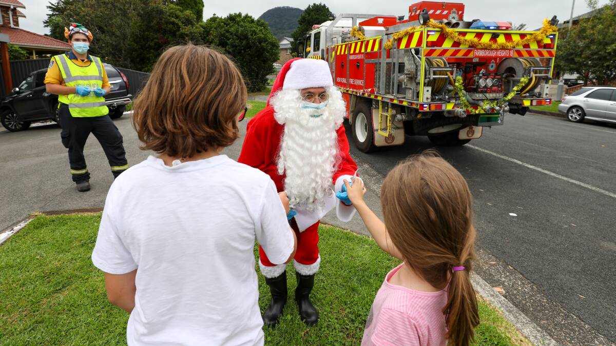 Santa hands out lollipops with the help of the Farmborough Heights RFS. Pictures: Adam McLean