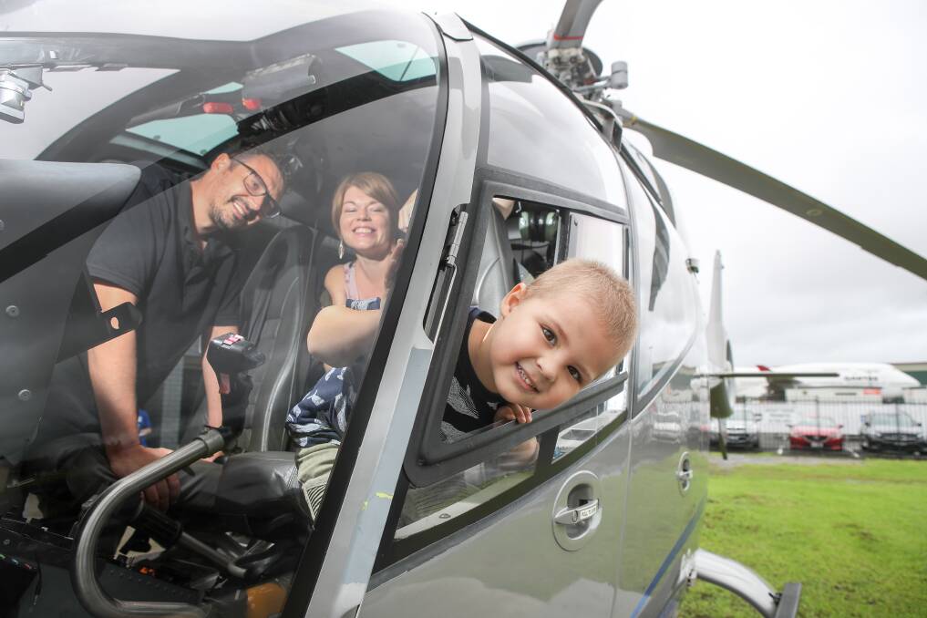 Zac Tomaz, with his parents Lara and Glaucco, at Touchdown Helicopters - a supporter of the Illawarra Convoy - where they were presented with food and fuel vouchers. Picture: Adam McLean