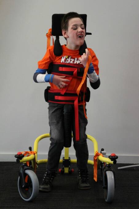 Support: Dexter Heffernan in his new walking aid which helps him stand and reduces the risk of muscle contractures.