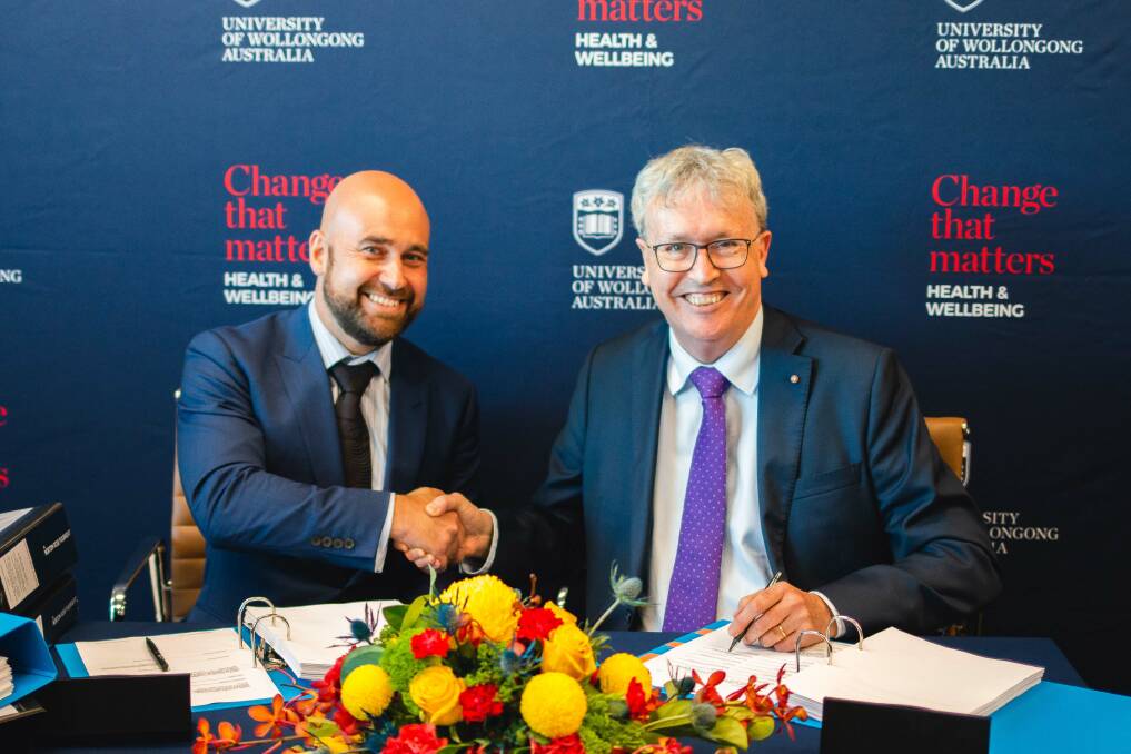 Lendlease's Tony Randello and UOW Vice Chancellor Professor Paul Wellings sign contracts.