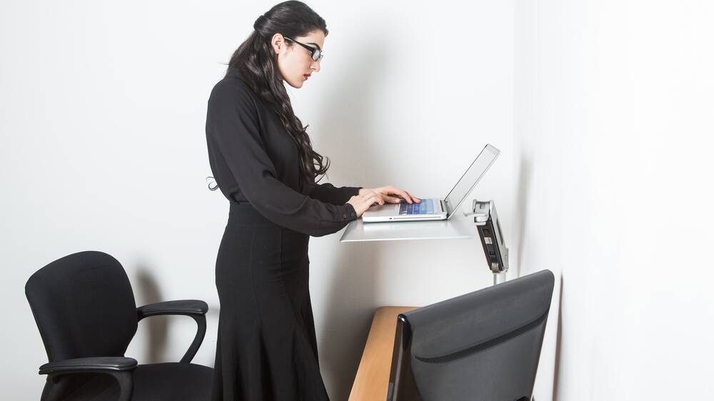 Workout at work: Using a stand-up desk at work is one of the ways you can continue to burn calories outside the gym, according to fitness expert Lukas Chodat.