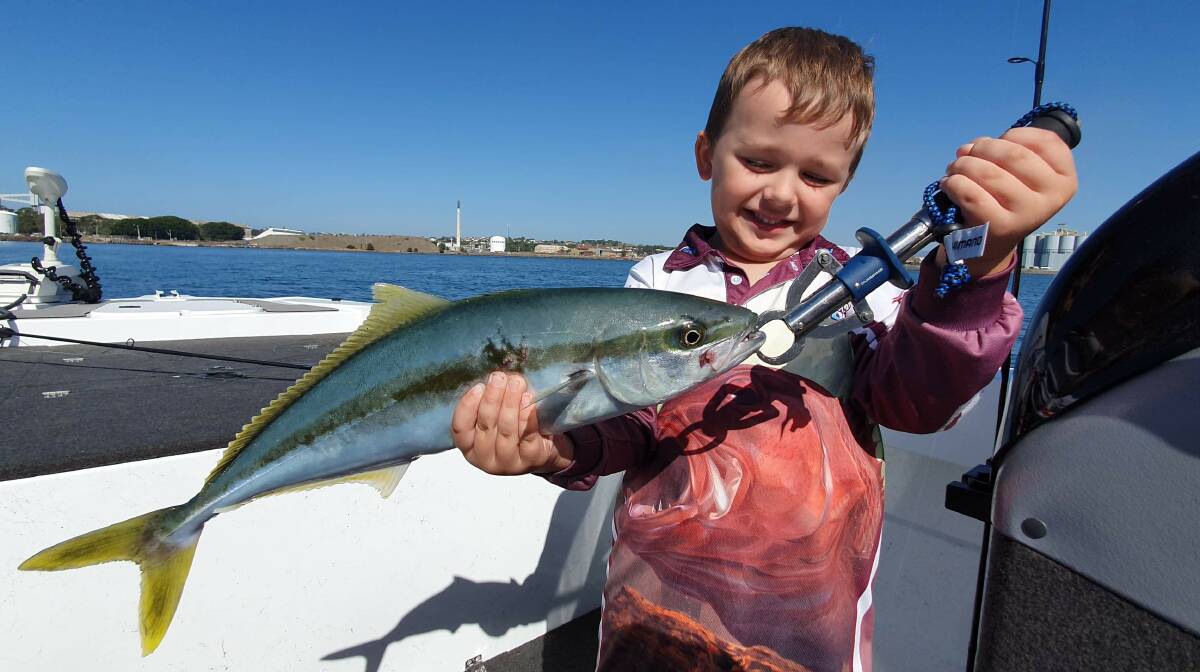 Great catch!: Mason Josevski shows off his kingfish just before release. Perfect weather has attracted lots of families to the coast during the school holidays.