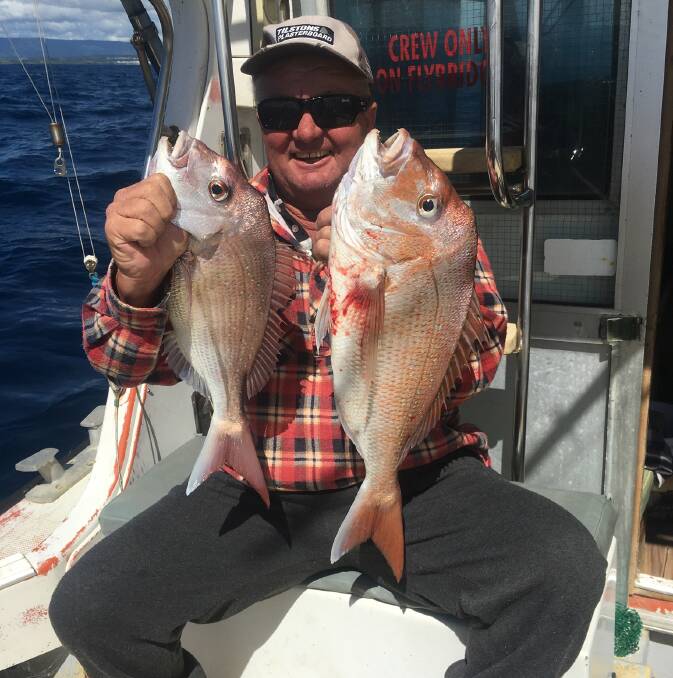 Wes McKenna with a pair of reds from a Shellharbour Fishing Charters trip.
