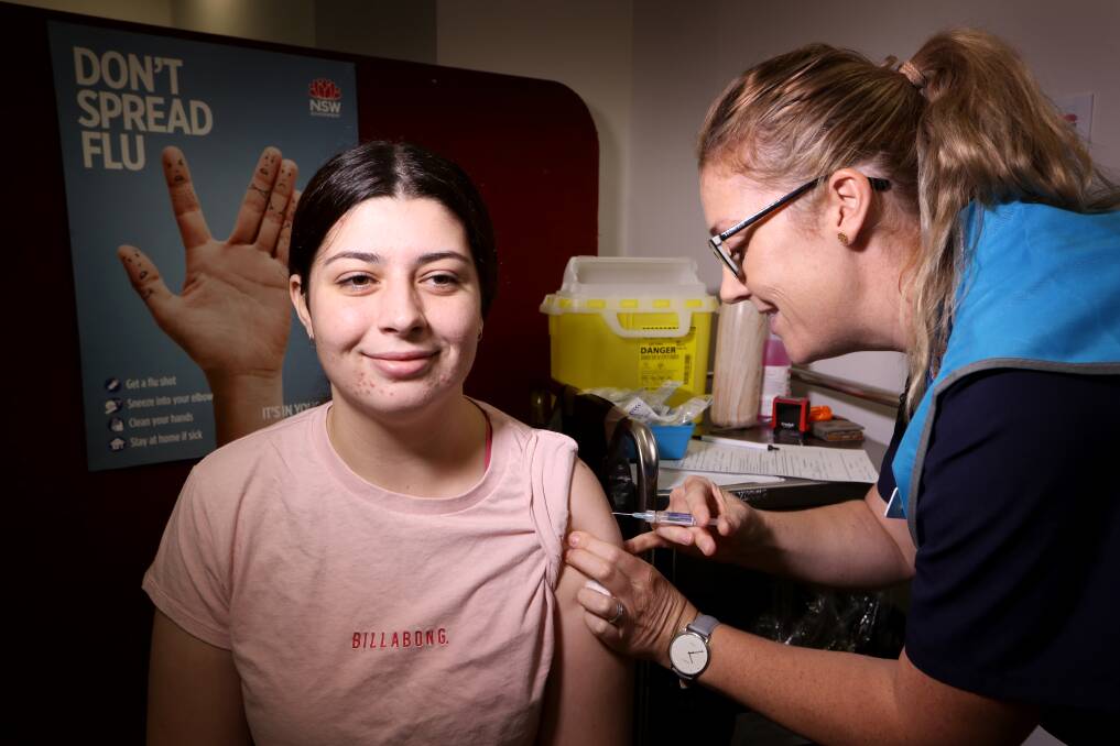 GETTING JABBED: Caitlyn Lees gets a free flu shot from Wollongong nurse Haley Frew. Picture: Sylvia Liber.