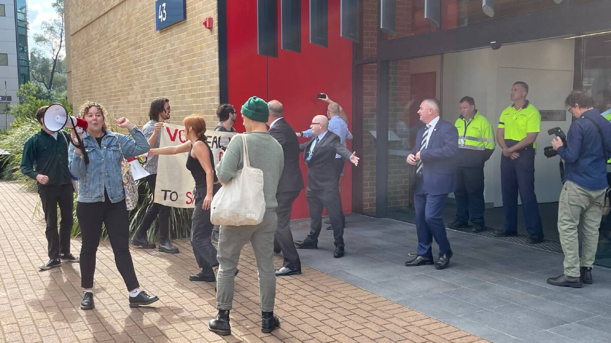 PROTESTORS: Police and security ensured the student protestors at UOW were kept away from the official opening of the Paul Wellings Building.