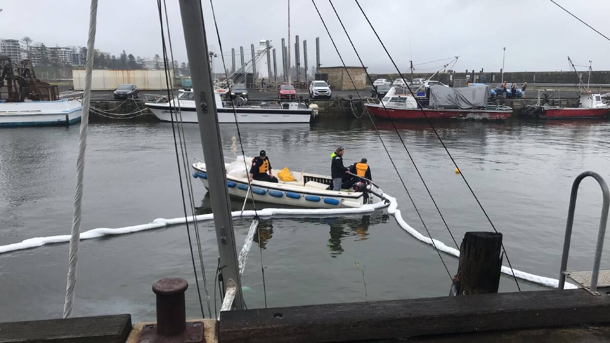 Absorbent booms being laid to contain a slight fuel spill from the yacht that sank in Belmore Basin. Pictures: Supplied