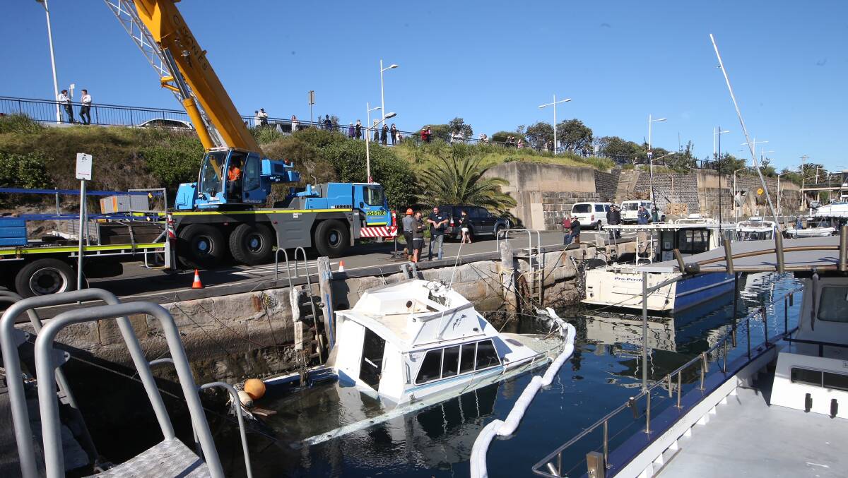 This six-metre long cruiser is being craned out of Wollongong Harbour after it sunk overnight. Picture: Sylvia Liber