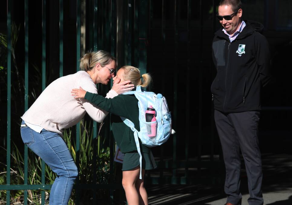 HAPPY TEARS: Kirstie Buggy kissing her daughter Marnie Pauley watched on by principal Paul Cuthbertson outside Russell Vale Public School. Picture: Robert Peet