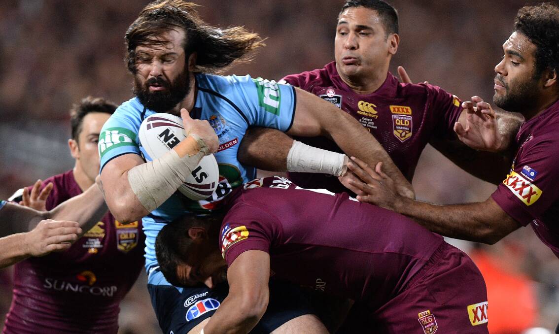 CHARGING: NSW player Aaron Woods tackled by Queensland player during Game 3 at Suncorp Stadium of the 2015 State of Origin series. Picture: Bradley Kanaris of /Getty Images.