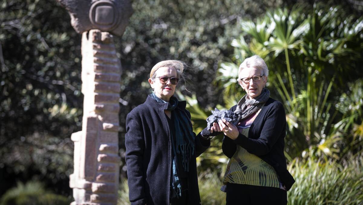 UOW alumna Jules McCue and UOW Art Collection director Senior Professor Amanda Lawson check out the Winged Bull while standing behind another of May Barrie's work, the Viva Solaris sculpture located on the McKinnon Lawn. Picture: Paul Jones