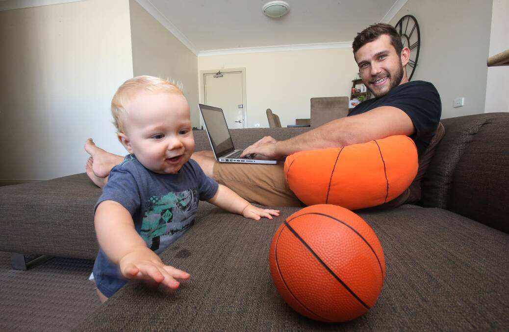 BALLER: Illawarra Hawks basketballer Tyson Demos, pictured here with his eight-month-old son Kayden, is studying to become a youth worker. Picture: Robert Peet  