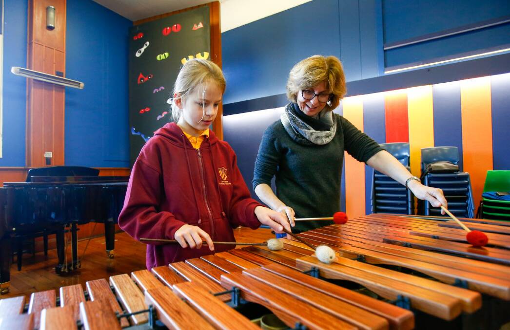 IN TUNE: Sydney Symphony Orchestra principal percussionist Rebecca Lagos plays the marimba with Waniora Public School student Erin Wilkie. Picture: Adam McLean