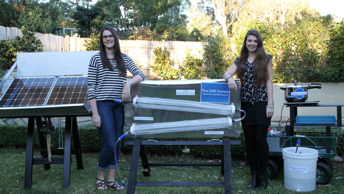 Multi award winning young scientists Macinley Butson (left) and Jade Moxey with their device, a world's first water filtration system to be solar powered, portable and deliver medical-grade sterile water.