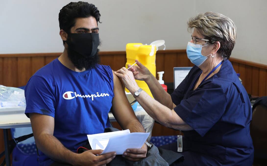 JAB TIME: Wollongong man Muhammad Rafique gets his AstraZeneca vaccine shot at Omar Mosque from Helen Calvert from the Illawarra Public Health Unit. Picture: Robert Peet