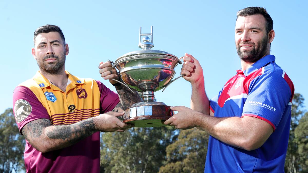 Shellharbour Sharks captain James Ralphs and his Gerringong Lions counterpart Nathan Ford hold aloft the Artie Smith Trophy, which will go to the winner of Sunday's grand final between the Sharks and Lions. Picture by Sylvia Liber