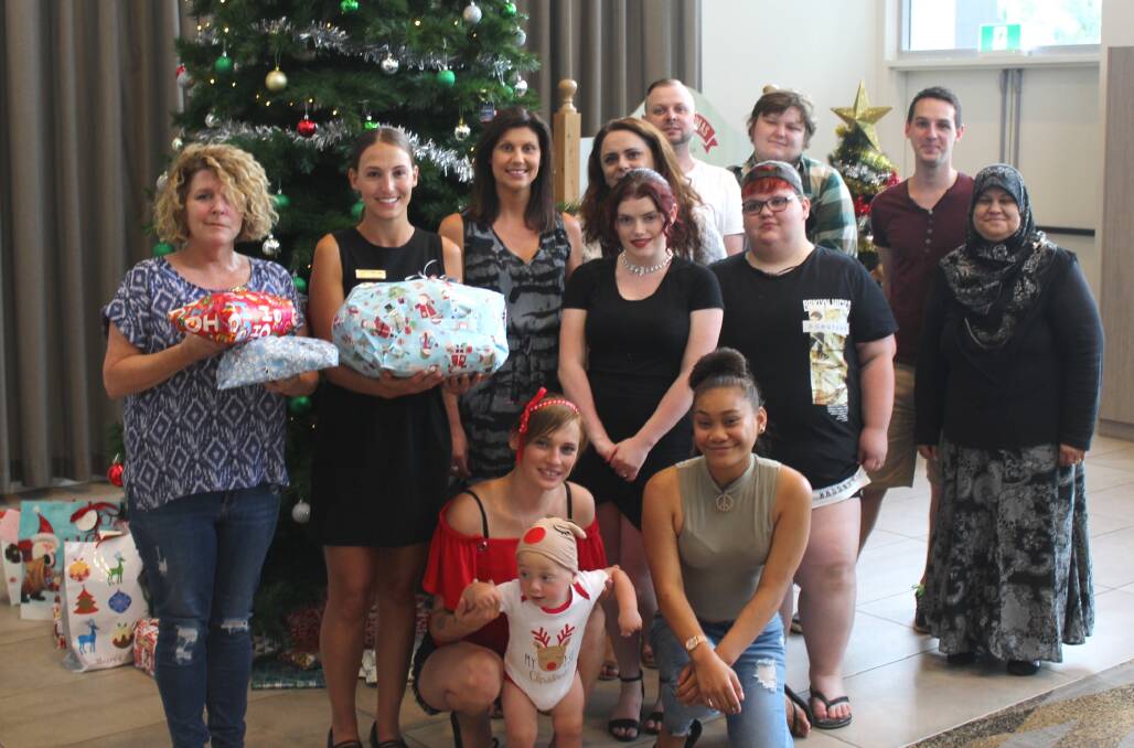 Southern Youth and Family Services residential manager Lisa Bolt (left) and
Fraternity Club marketing and events manager Courtney Steltenpool with those people who received gifts from SYFS on Wednesday.