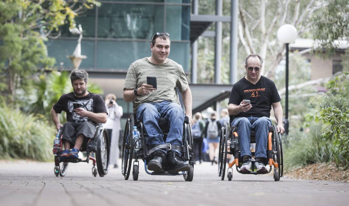SAFER RIDE: Ashley James, Jason Jones and Mark Tomkins check out the Navability App, which shows the best routes for wheelchair users based on their relative ability to propel a wheelchair.