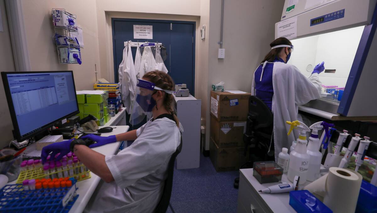IML pathology laboratory scientists Stephanie Ivkosic and Hannah Bowen (on the computer) at the Wollongong lab testing samples collected at the Illawarra COVID-19 testing sites. Picture: Adam McLean