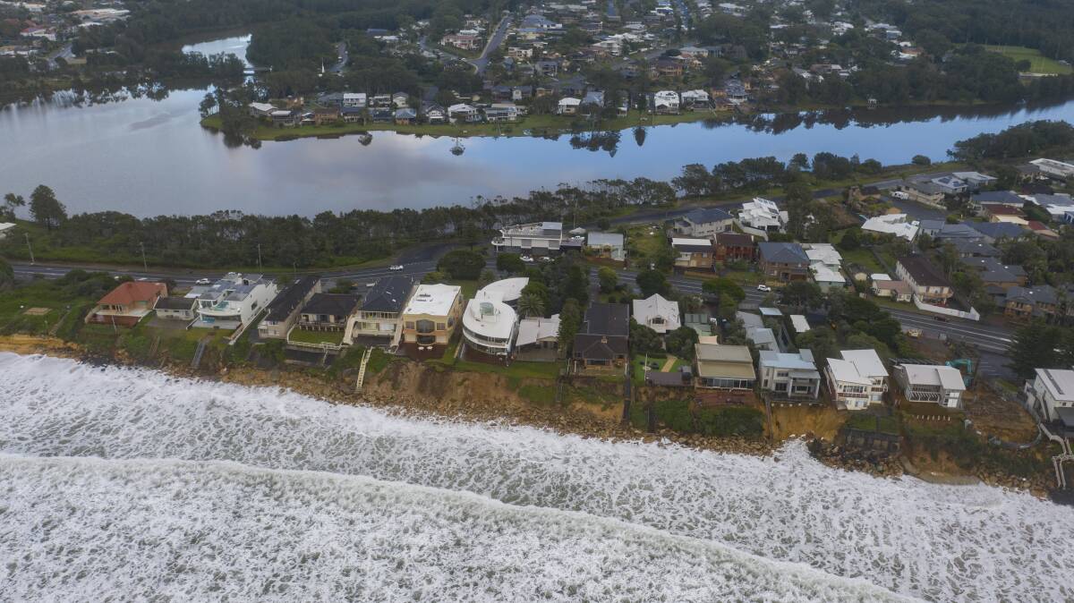 UNDER THREAT: Waves surge towards houses at Wamberal on the Central Coast. There was also singificant erosion at The Entrance North. Pictures: Facebook