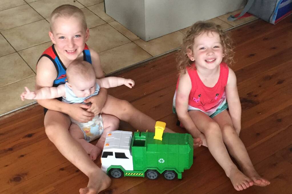 GIFT: Brett, 6, William, five-months-old and Alaska, 5, with their new toy delivered by their favourite garbage collector. 