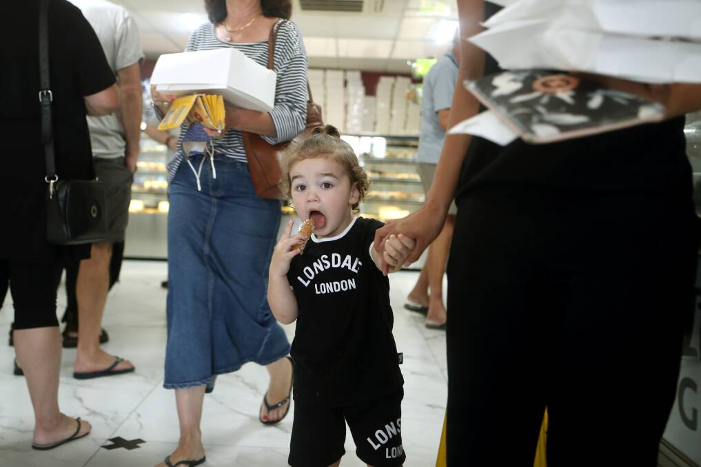 DELICIOUS: Lake Heights' Mason Gouvas, two, eating a cannoli at the Fairy Meadow store on Sunday. Picture: Sylvia Liber